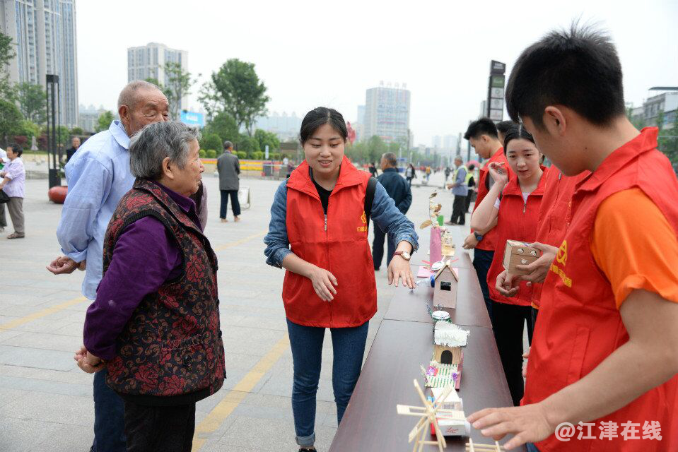 图为志愿者向市民介绍环保手工艺术品.png