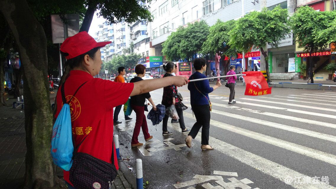 图为志愿者在指挥行人过公路3.png