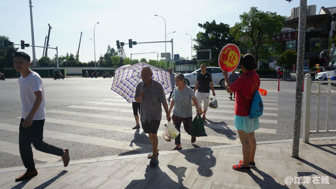 图为志愿者劝导行人安全过马路.png