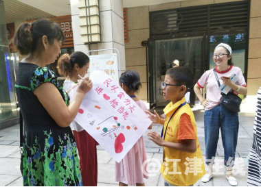 图为志愿者和公益小天使向各商铺和社区居民宣传食品安全知识3.png