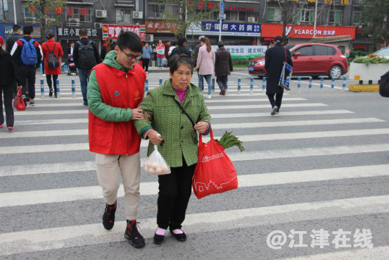 图为志愿者帮助行人过马路.png